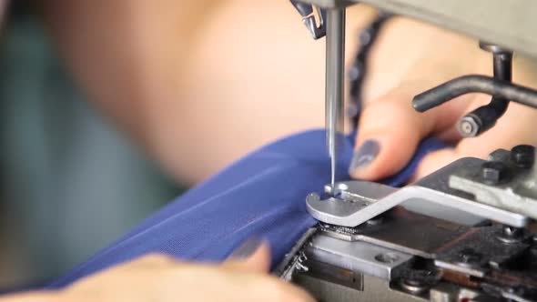 Seamstress Works on the Sewing Machine. alt