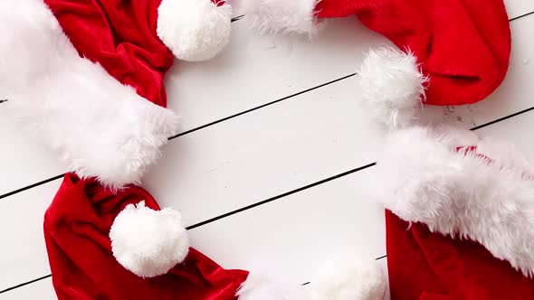 Santa Claus Hats on White Wooden Desk with Blank Copy Space. alt