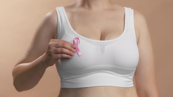 Caucasian Woman in a White Seamless Bra Put Pink Ribbon for Breast Cancer
