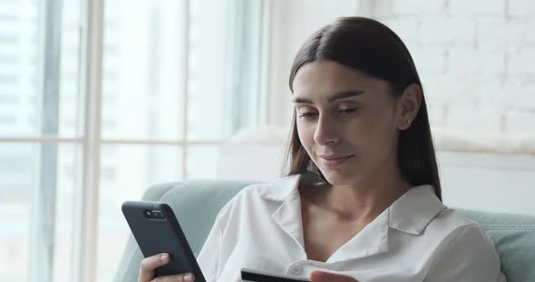 Happy Young Woman Using Smartphone and Credit Card for Instant and Secure Payments alt