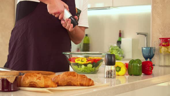 Man Seasoning Salad with Salt