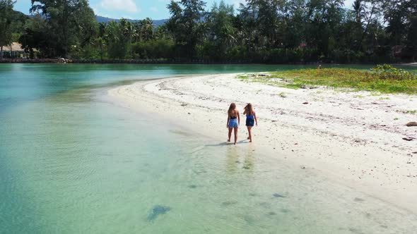 Girls happy and smiling on luxury tourist beach wildlife by blue ocean with white sandy background o alt