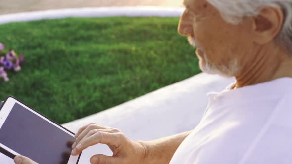 Portrait of Retirement Handsome Senior Man Using Tablet Computer on Seafront Close Up alt