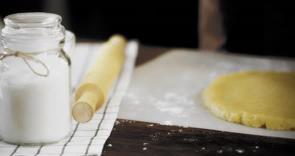 Women's Hands Form the Sides of the Rolled Dough
