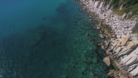 Aerial Shot of Mountain Cliff and Blue Sea Water alt