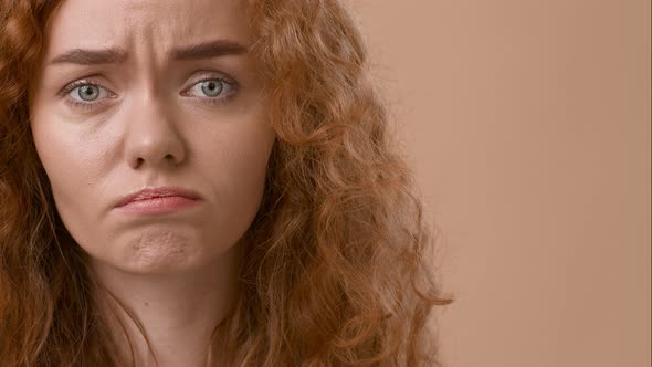 Sad RedHaired Woman Looking At Camera Expressing Frustration Beige Background alt