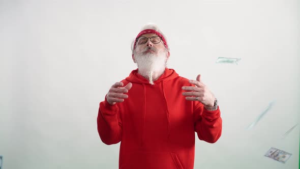 Grayhaired Man in a Red Hoodie Summons Money and Luck Dollar Bills Fall From Above Caucasian Man on alt