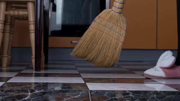 Young Girl Sweeps the Floor in the Kitchen with an Ordinary Broom in Slow Mo alt