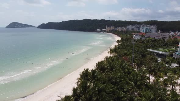 Aerial View of the Blue Ocean on an Island with White Sand Palm Trees Along the Beach at a Resort in alt