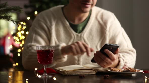 man sitting at the Christmas table with a cell phone