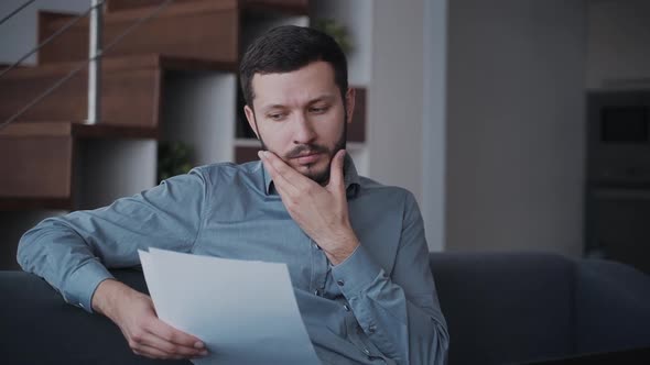 Man Reading Important Working Documents and Spending Time at Hom alt