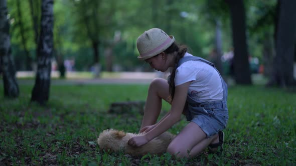 Child Girl Playing with a Toy Poodle Dog Outdoors alt