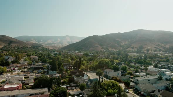 Aerial view of american suburb, San Luis Obispo. Drone flies forward over residential area, United S alt