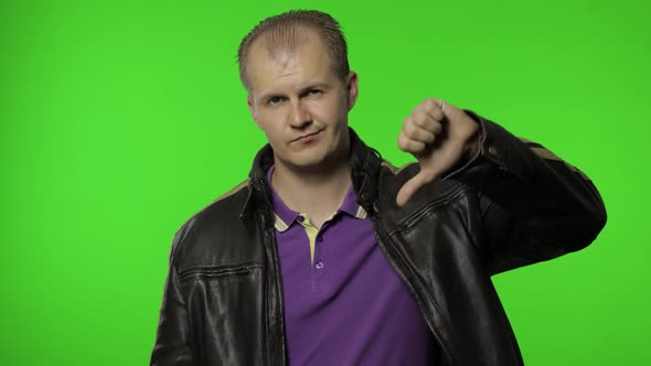 Man Pointing To Camera and Showing Thumbs Down, Making Disapproval Sign, Dislike, Disapproval alt
