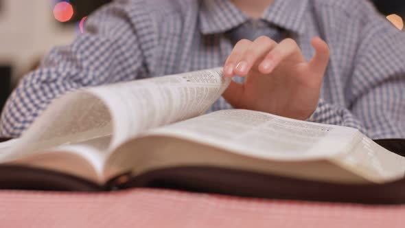 Boy's Hand Turns Book Pages. alt