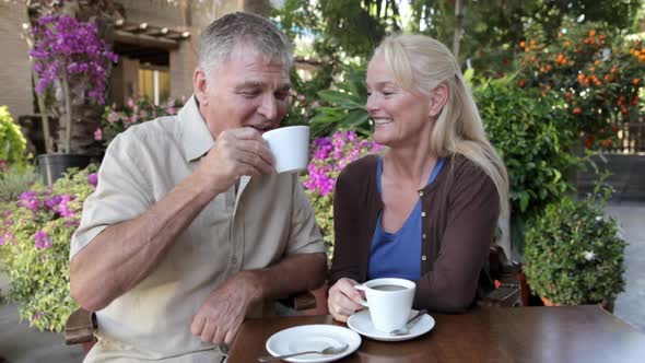 Mature couple having coffee alt