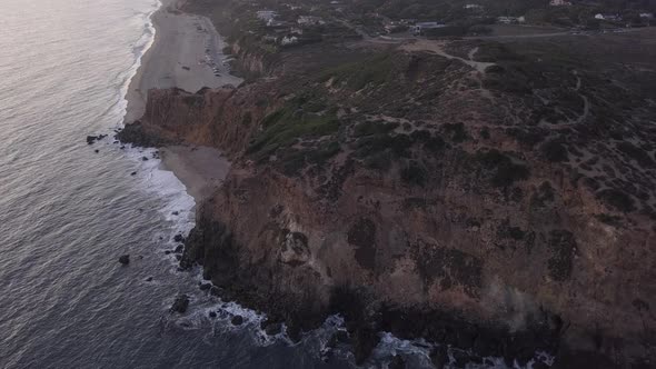 AERIAL: Flight Over Malibu, California View of Beach Shore Line Pacific Ocean at Sunset with alt