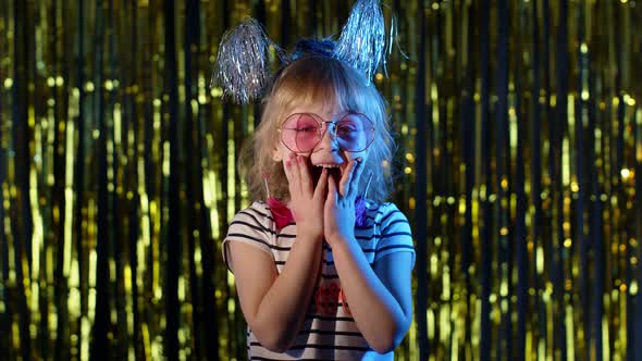 Trendy Girl Raising Hands in Surprise Looking at Camera with Big Eyes Shocked By Victory Say Wow alt