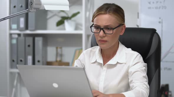 Businesswoman Nervously Taking Off Eyeglasses and Closing Laptop, Work Problem