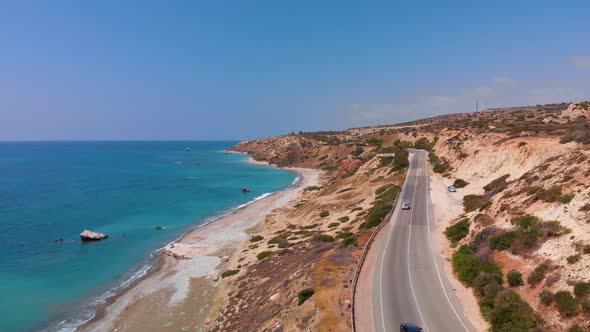 Aerial view flying over a road near the beach and coast of the Mediterranean Sea in Paphos Cyprus alt
