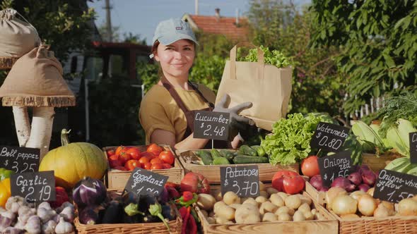 Farmer Seller Holding Eco Paper Bag with Fresh Vegetables alt