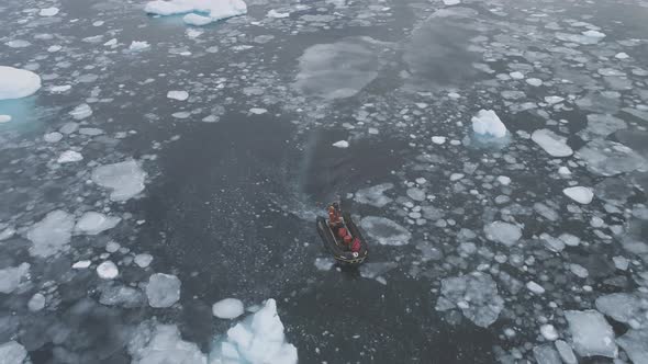 Zodiac Motor Boat in Icebergs Tracking Aerial Top Down View alt