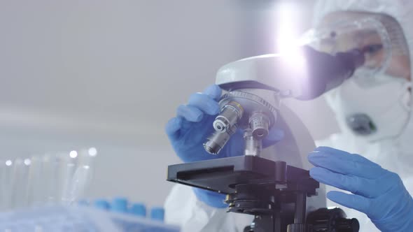 Medical Scientist Looking at Sample under Microscope alt