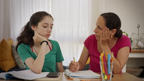 Mother helping her teenage daughter prepare homework alt