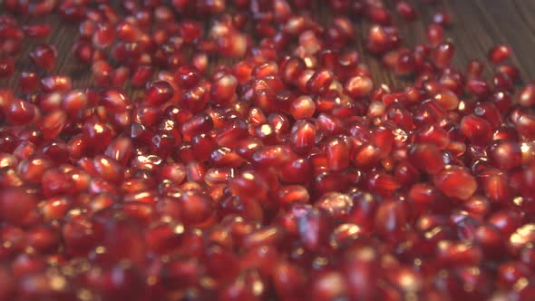 Pomegranate Grains on Brown Wooden Background.