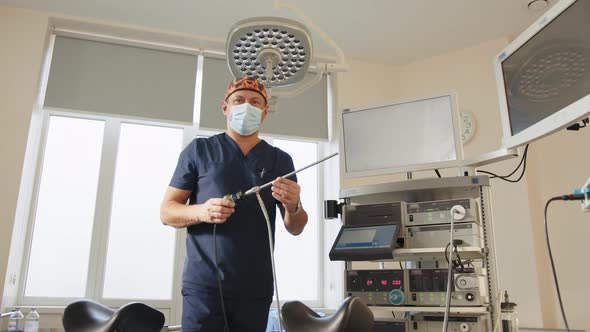 Portrait of a Focused Doctor Holding a Laparoscopic Instrument Looking at the alt