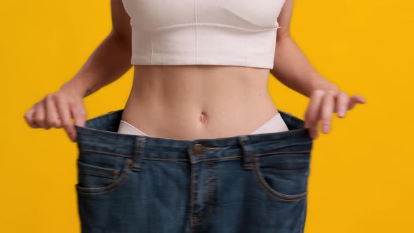 Unrecognizable Slim Woman Wearing Big Jeans Showing WeightLoss Yellow Background alt