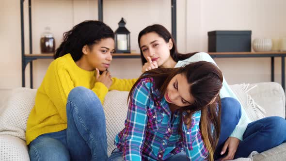 Diverse women gossiping behind back of roommate alt