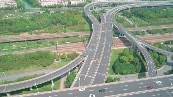 Aerial View of a Highway Overpass Multilevel Junction with Fast Moving Cars Surrounded By Green alt