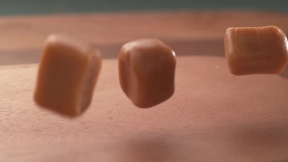Caramel candy falling onto wooden surface in super slow motion.  Shot on Phantom Flex 4K high speed 