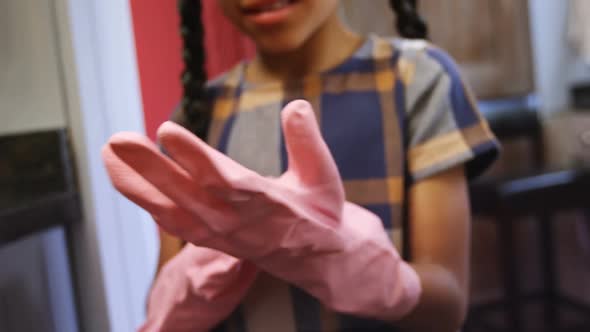 Girl wearing gloves in kitchen 4k alt