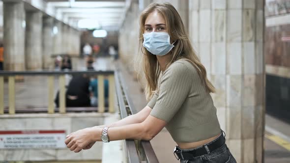 Masked Passenger Waiting Train Subway Corona Virus. Girl Look at Camera Covid-19 alt
