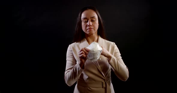 Portrait of a Woman with Long Hair and a Formal Dress on a Black Background. She Holds a Disposable alt