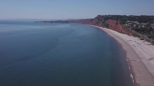 Flying over the ocean water and shore of Budleigh Salterton beach in East Devon England. This locati alt