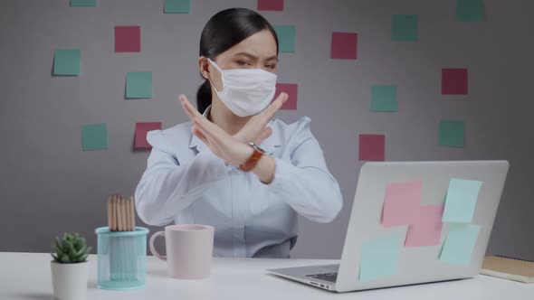 Asian woman wearing protective face mask showing arms crossed