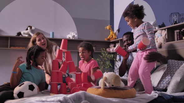 Diverse Dad and Mom Playing with Children on Bed alt