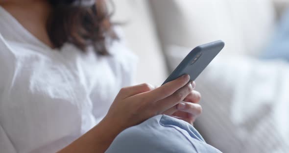 Woman use of smart phone and lying down on sofa alt