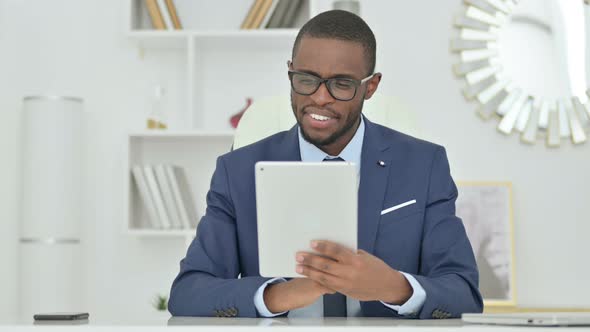 Portrait of Attractive African Businessman Doing Video Call on Tablet  alt