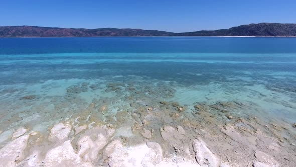 White Sandy Coral Reef in the Clear Turquoise Light Blue Sea of the Tropical Coastline alt