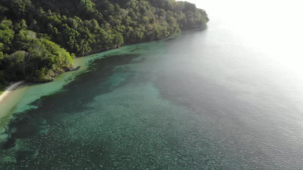 Aerial: flying over tropical white sand beach Banda Islands Maluku Indonesia alt