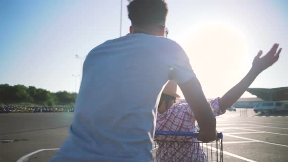 Young Friends Having Fun on Shopping Trolleys alt