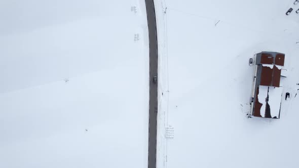 SUV vehicle driving on a Norwegian country road in Norway, Bird view following shot 4k. alt