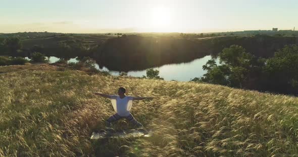 Girl meditates on a beautiful meadow at sunset alt