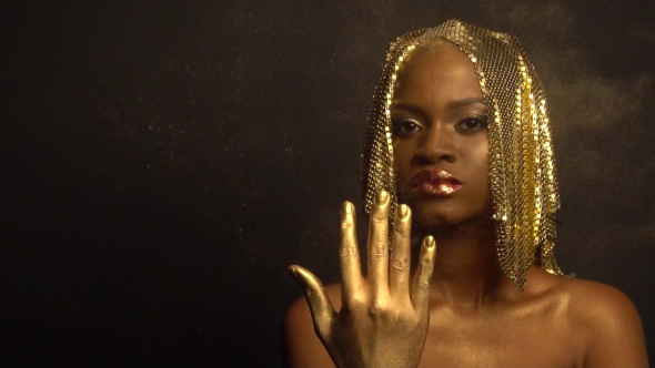 Fashion Portrait Of Glossy African American Woman With Bright Golden Makeup Surrounded By Golden