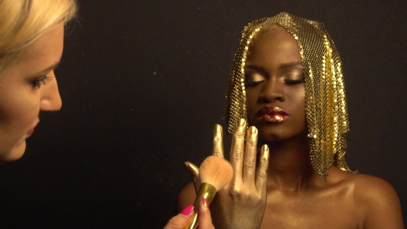 Of Makeup Process. Magic Golden African American Model With Bright Glitter Makeup And Golden Glossy