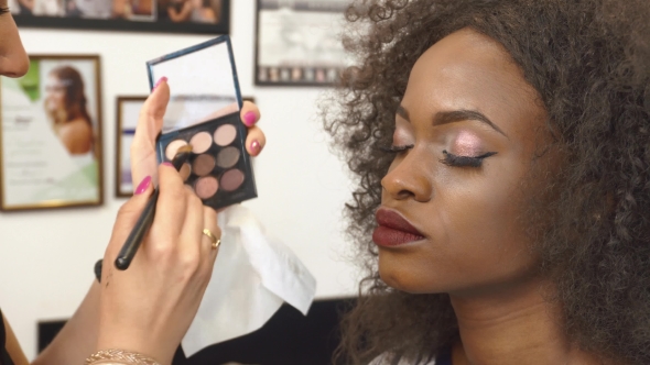 Makeup Artist Applying Makeup On Black African American Eye Lashes Model. Pretty Young Girl Getting